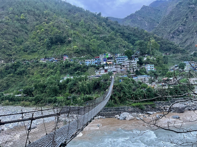 Machha Khola village and suspension bridge over the river in Nepal.