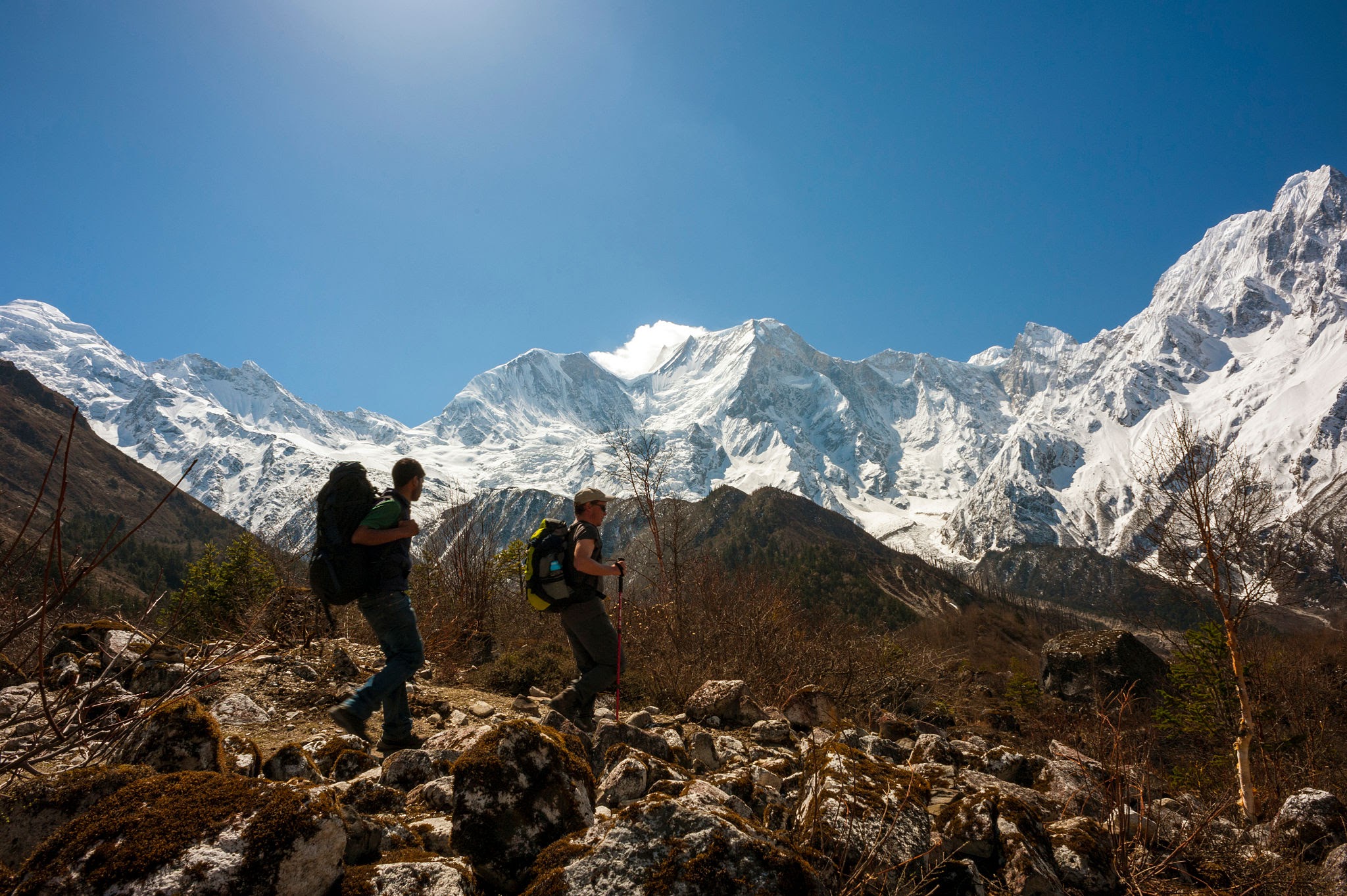Trekkers walking through the Himalayan landscape on the Manaslu Circuit Trek